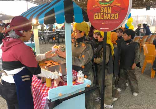 personas frente a puesto de comida en fiesta o reunión social