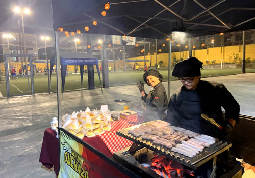 personas en un evento deportivo frente a puesto de catering de comidas