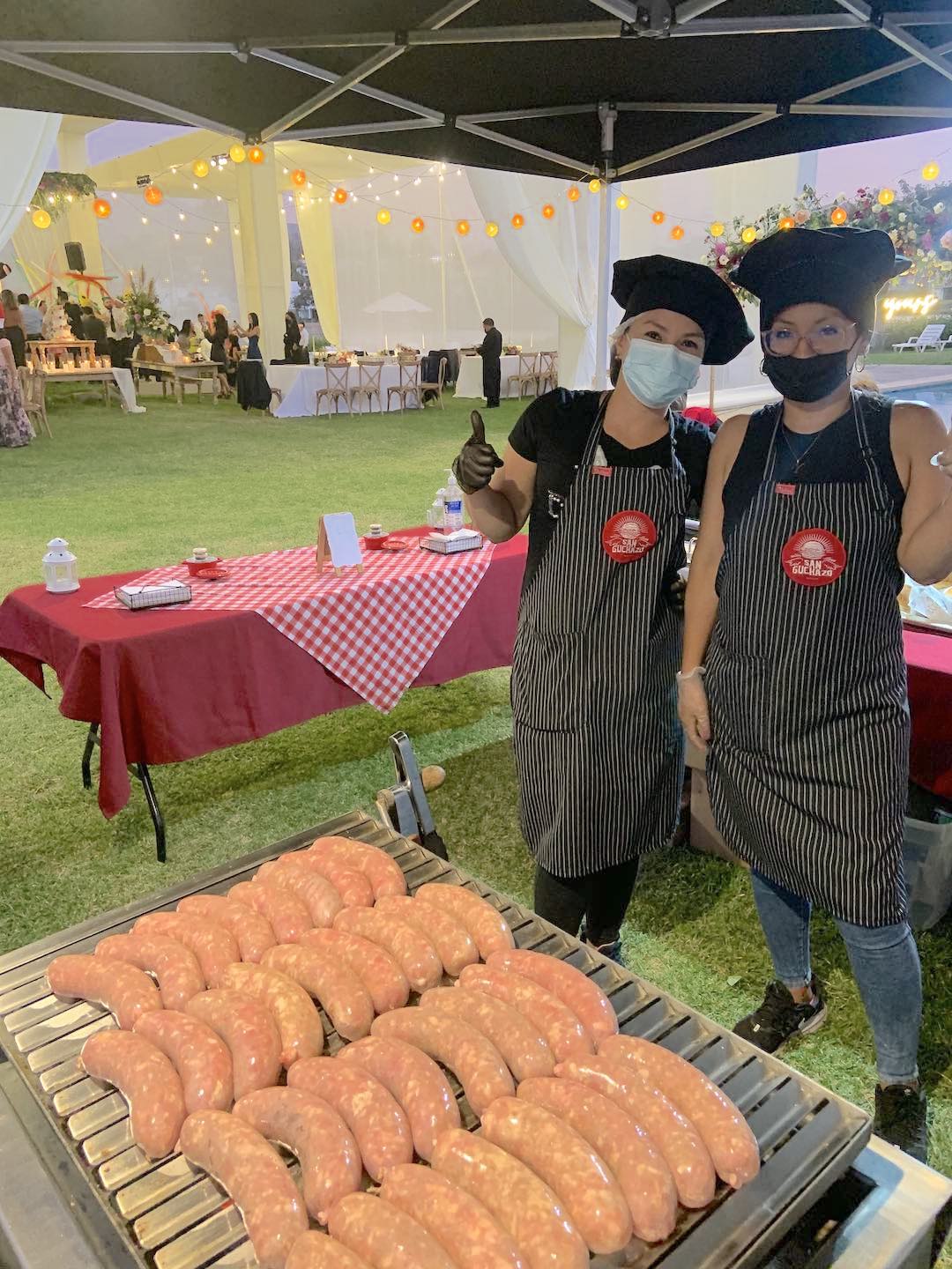 mujer preparando hamburguesas en un evento sobre una plancha en carrito snack