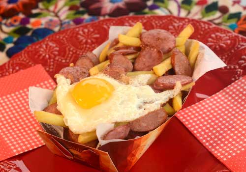 Salchipapas para eventos y fiestas servidas en una mesa de comidas